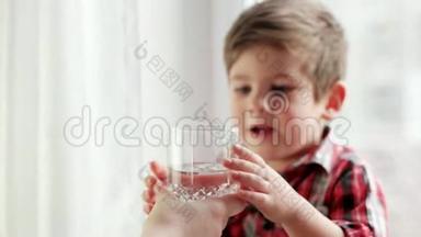 妈妈给她口渴的儿子端来一杯水，小男孩端来一杯水，妈妈来照顾她